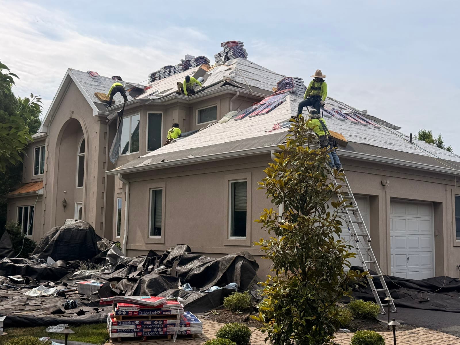 Crew installing roof on large stucco home — Green Apple Roofing, New Jersey