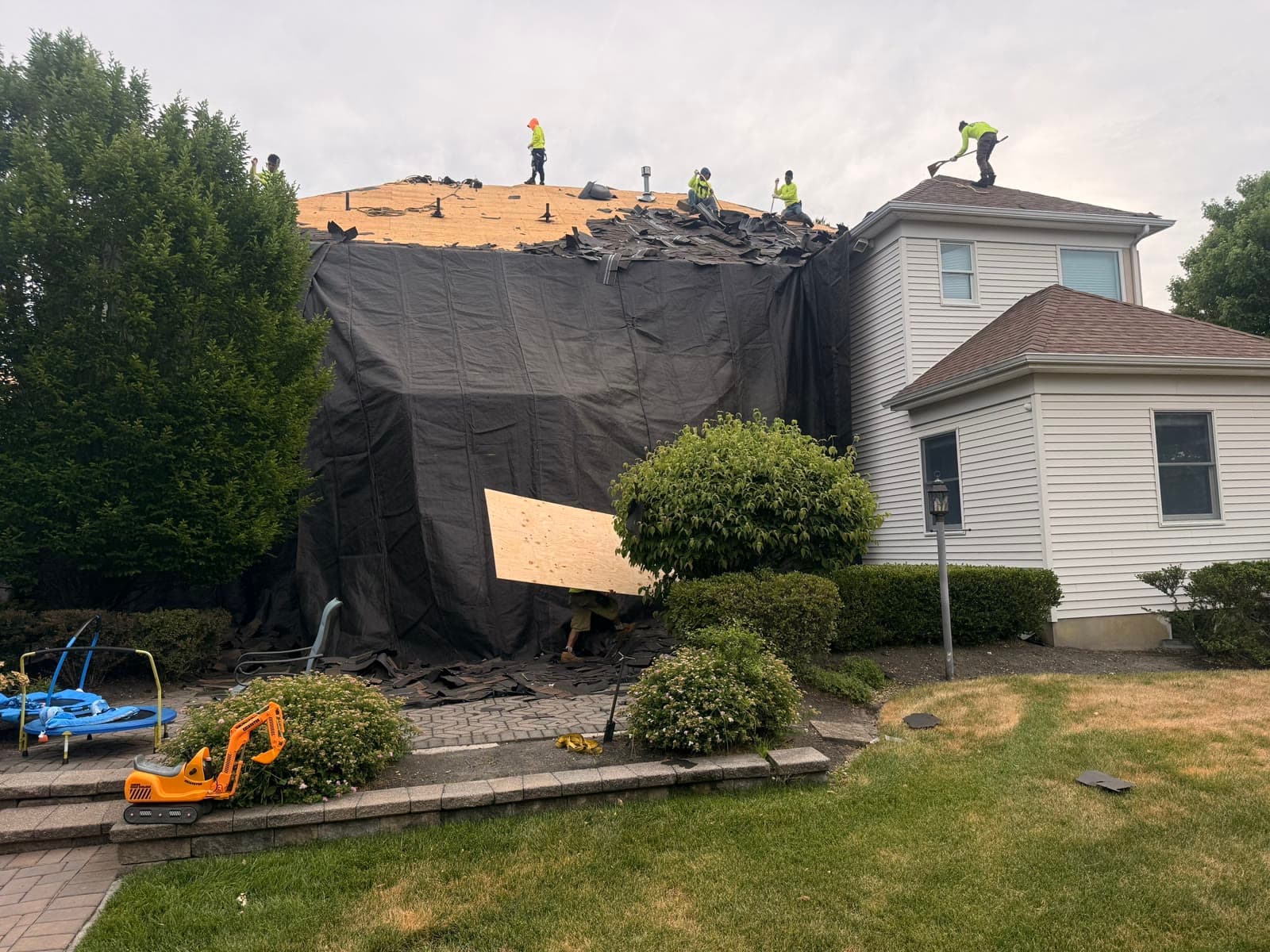 Crew installing decking on tarped home — Green Apple Roofing, New Jersey