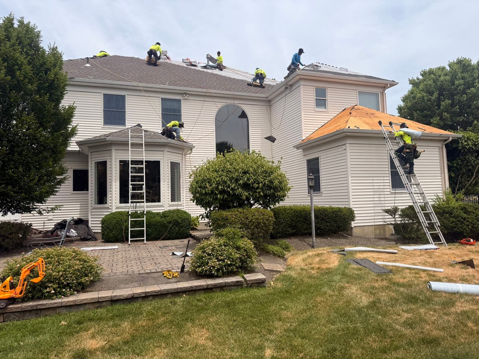 Crew across back of white home, ladders — Green Apple Roofing, New Jersey