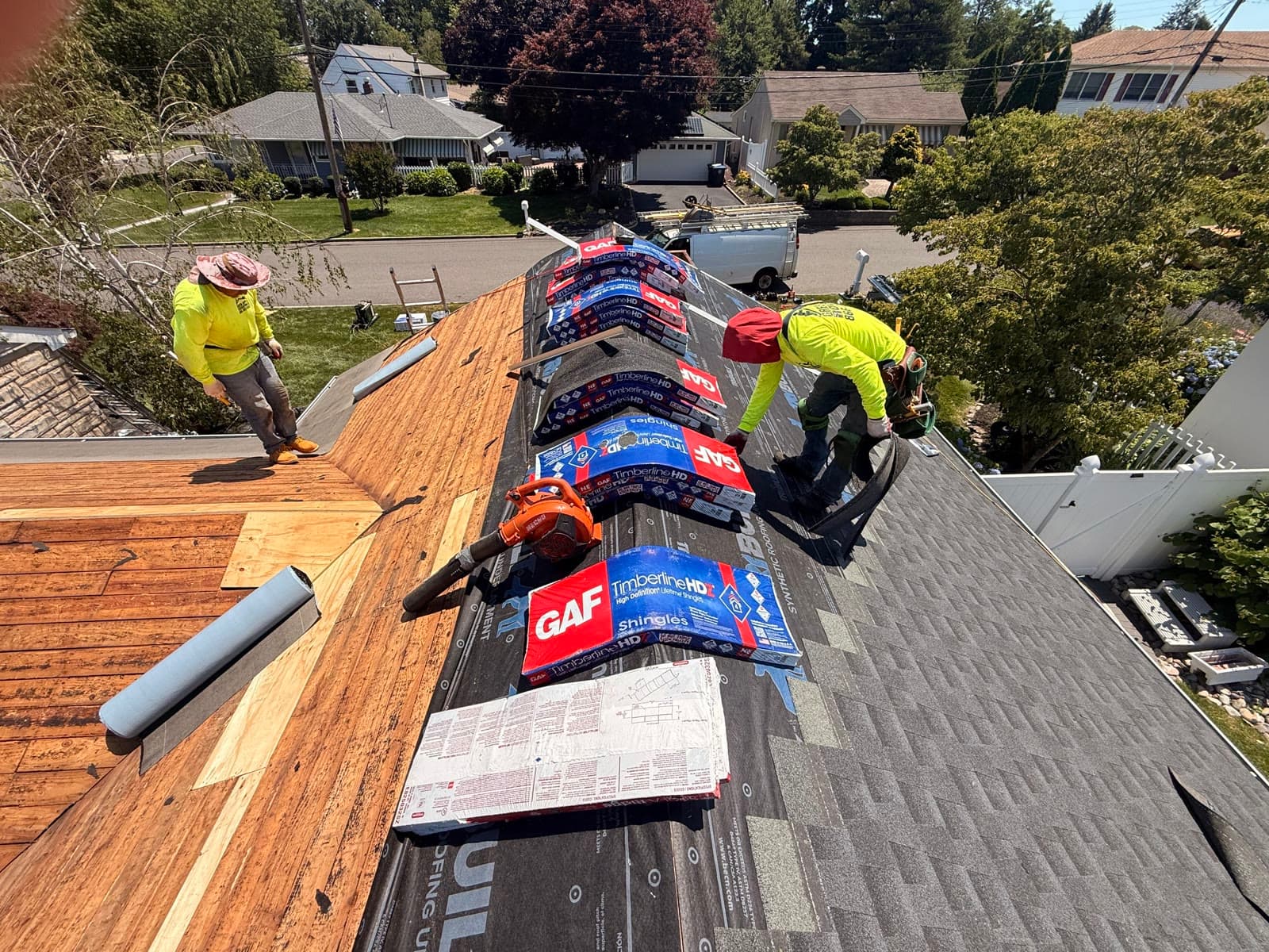 Two crew laying GAF shingles, rooftop view — Green Apple Roofing, New Jersey