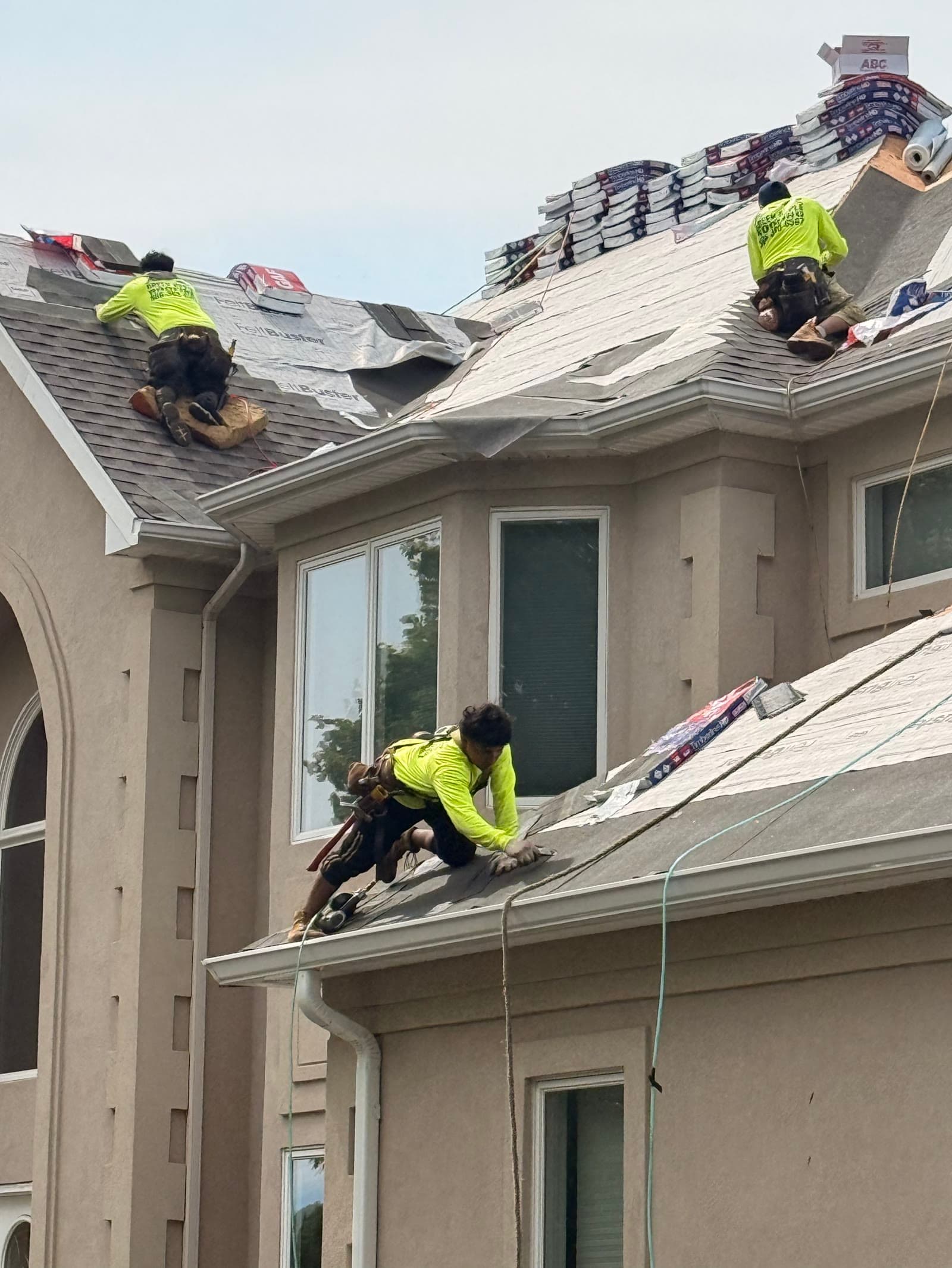 Crew installing shingles on stucco home — Green Apple Roofing, New Jersey