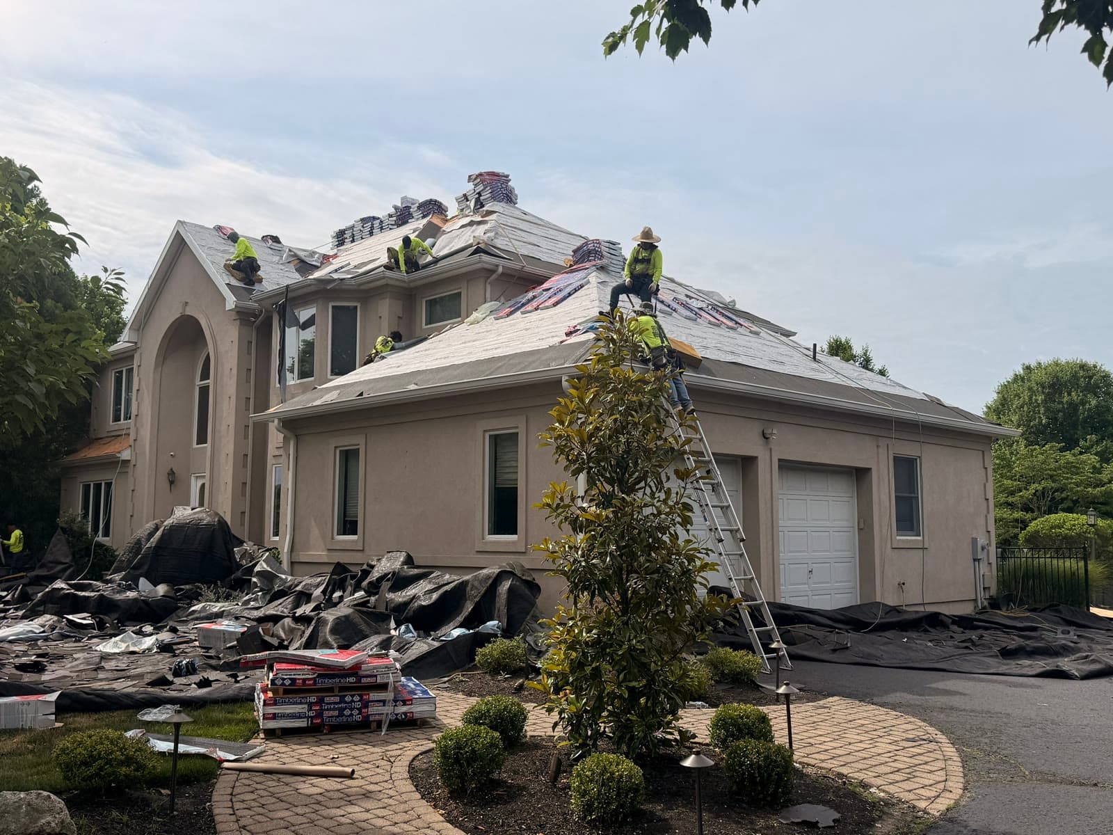 Crew tearing off roof, luxury stucco home — Green Apple Roofing, New Jersey