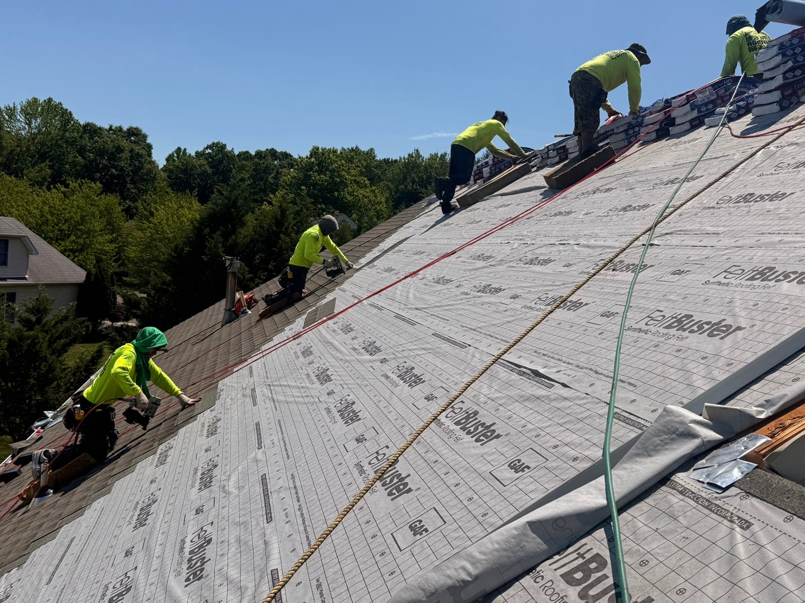 A crew installing synthetic underlayment across a large roof — Green Apple Roofing, New Jersey