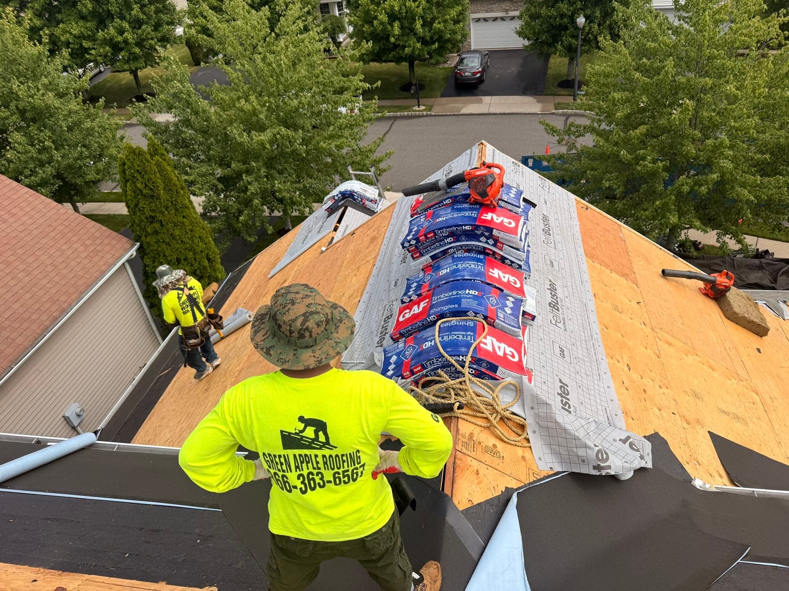 A Green Apple roofer working with shingle bundles on the deck — Green Apple Roofing, New Jersey