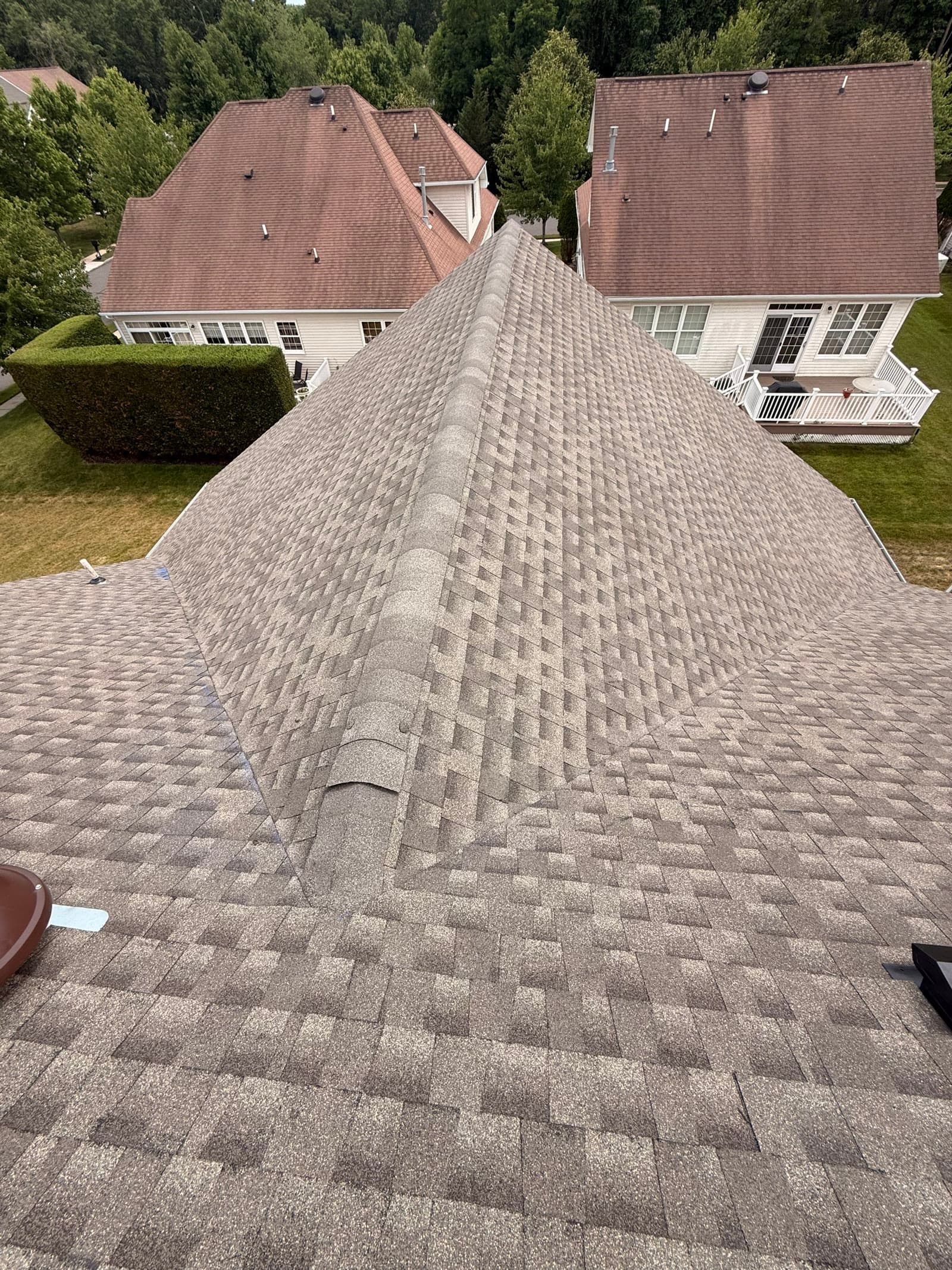 Aerial ridge view of a finished roof over a wooded valley — Green Apple Roofing, New Jersey