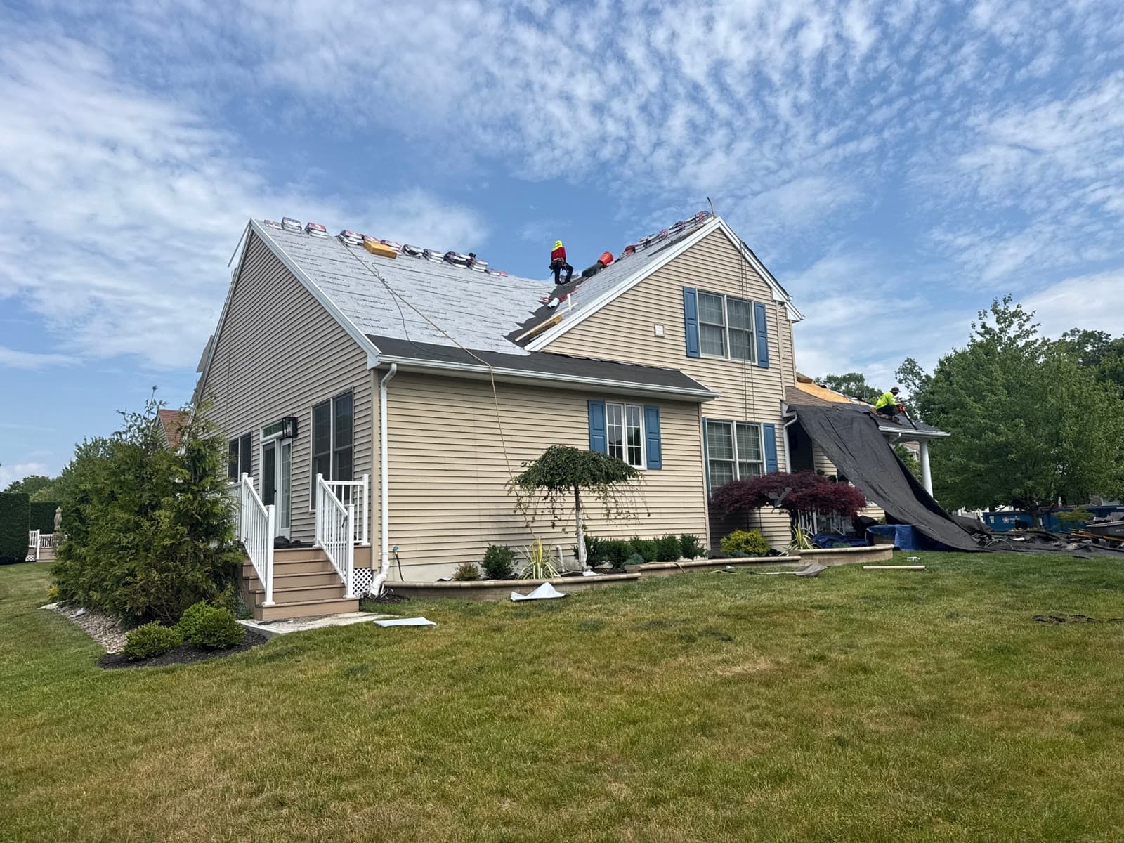 A full crew installing a new roof on a two-story home — Green Apple Roofing, New Jersey