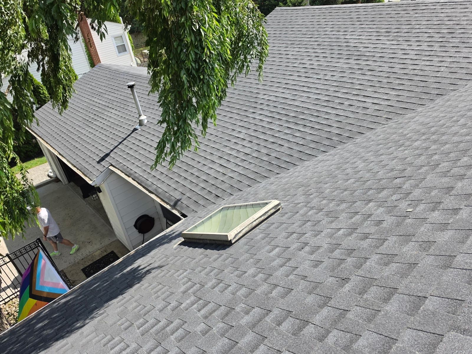 A skylight set into a finished gray shingle roof — Green Apple Roofing, New Jersey