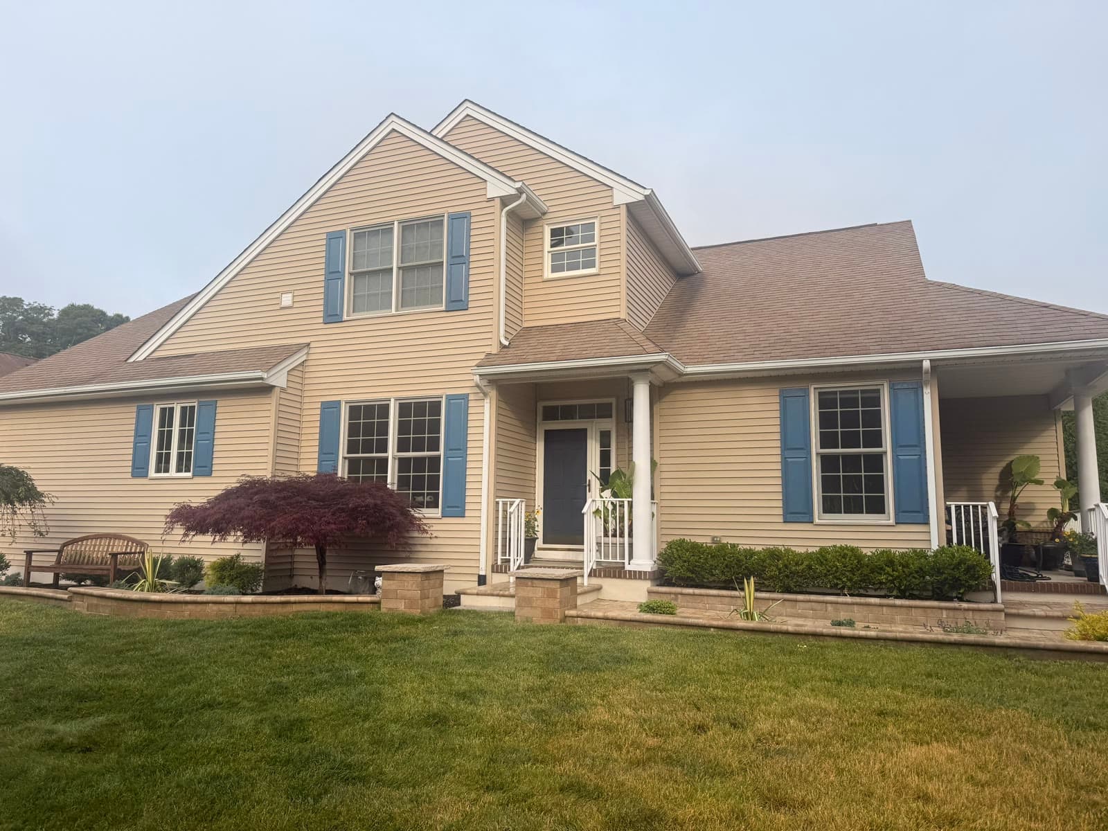 Tan colonial home with blue shutters and a new roof — Green Apple Roofing, New Jersey