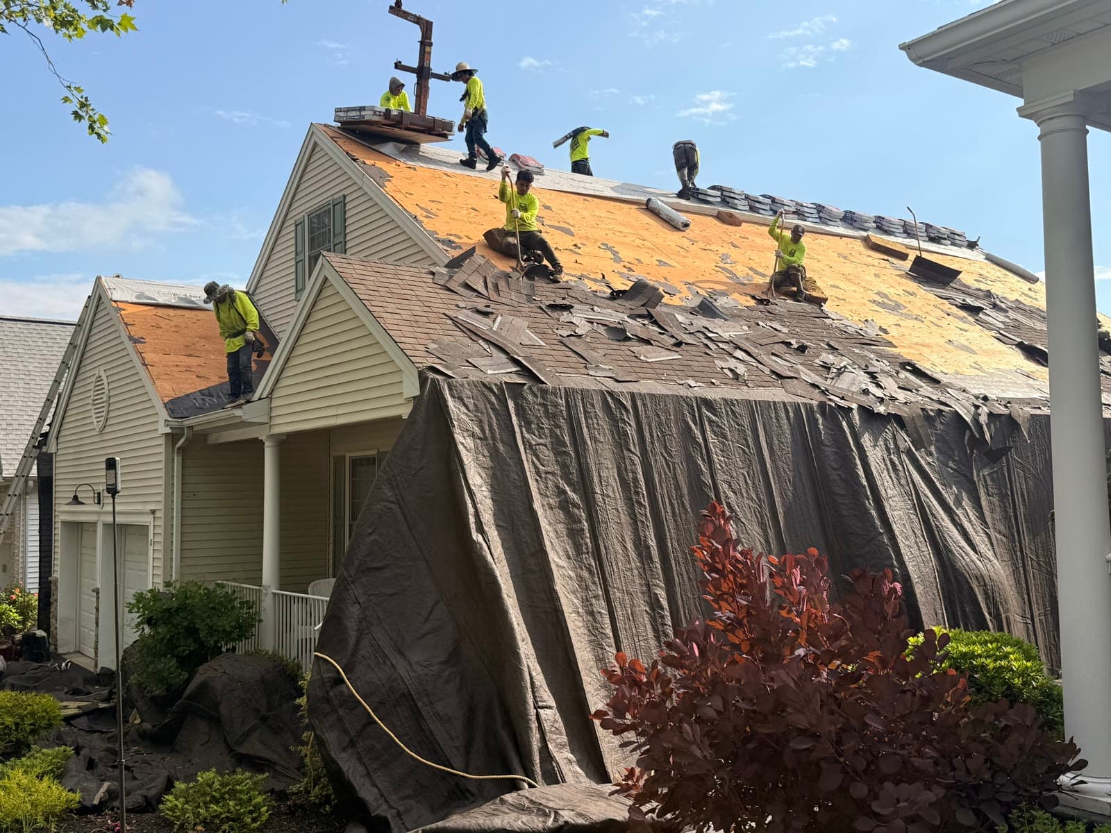 A large crew tearing off and rebuilding a roof — Green Apple Roofing, New Jersey