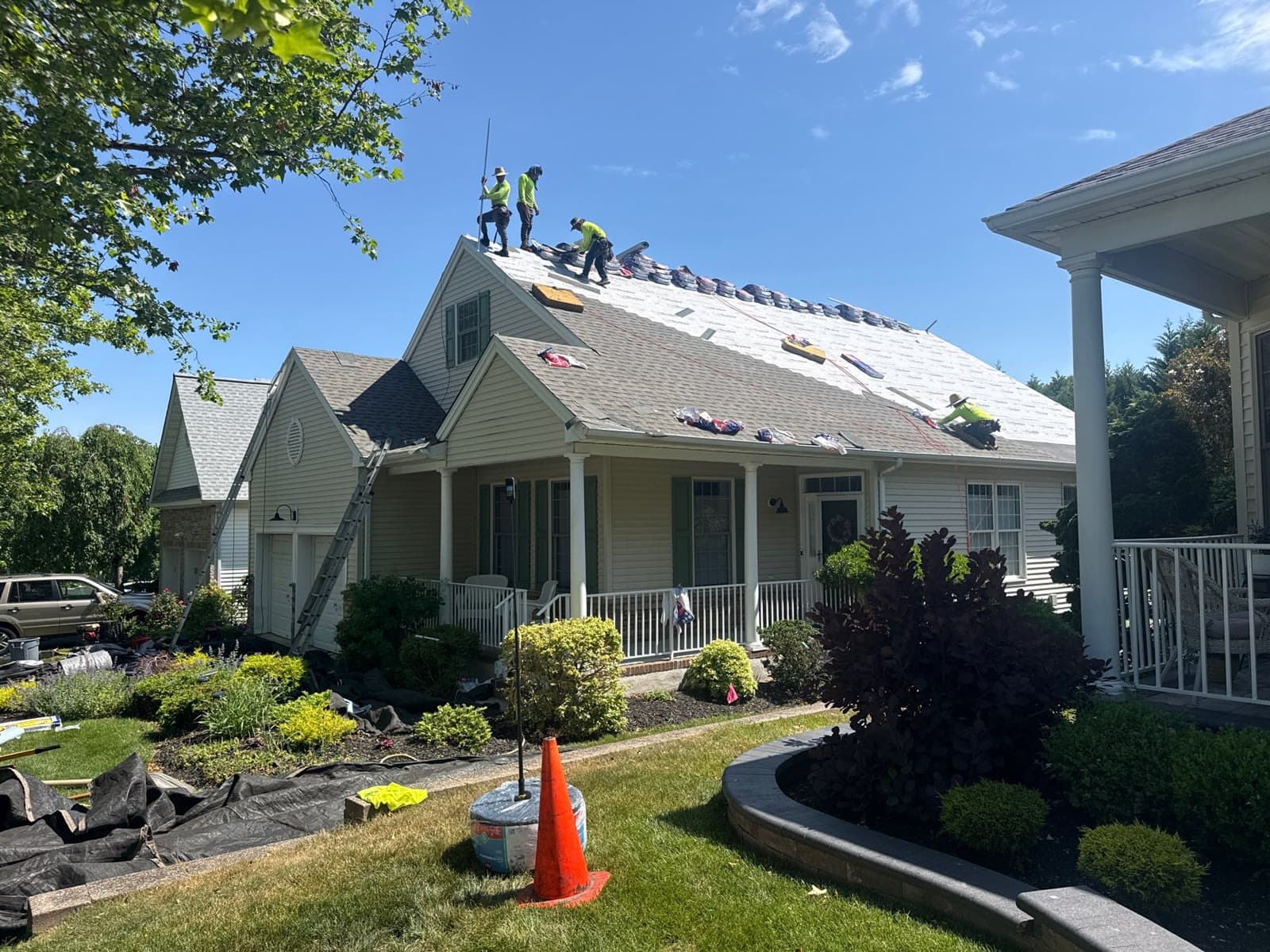 A crew re-roofing a home under blue sky — Green Apple Roofing, New Jersey