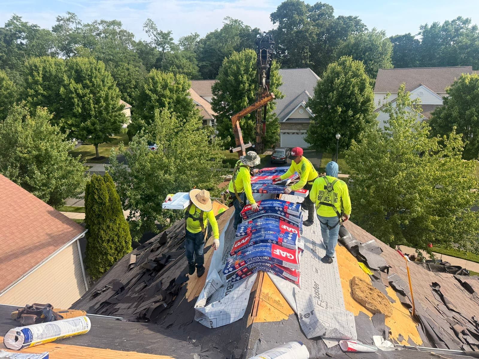 Hoisting shingle bundles to the ridge by crane — Green Apple Roofing, New Jersey