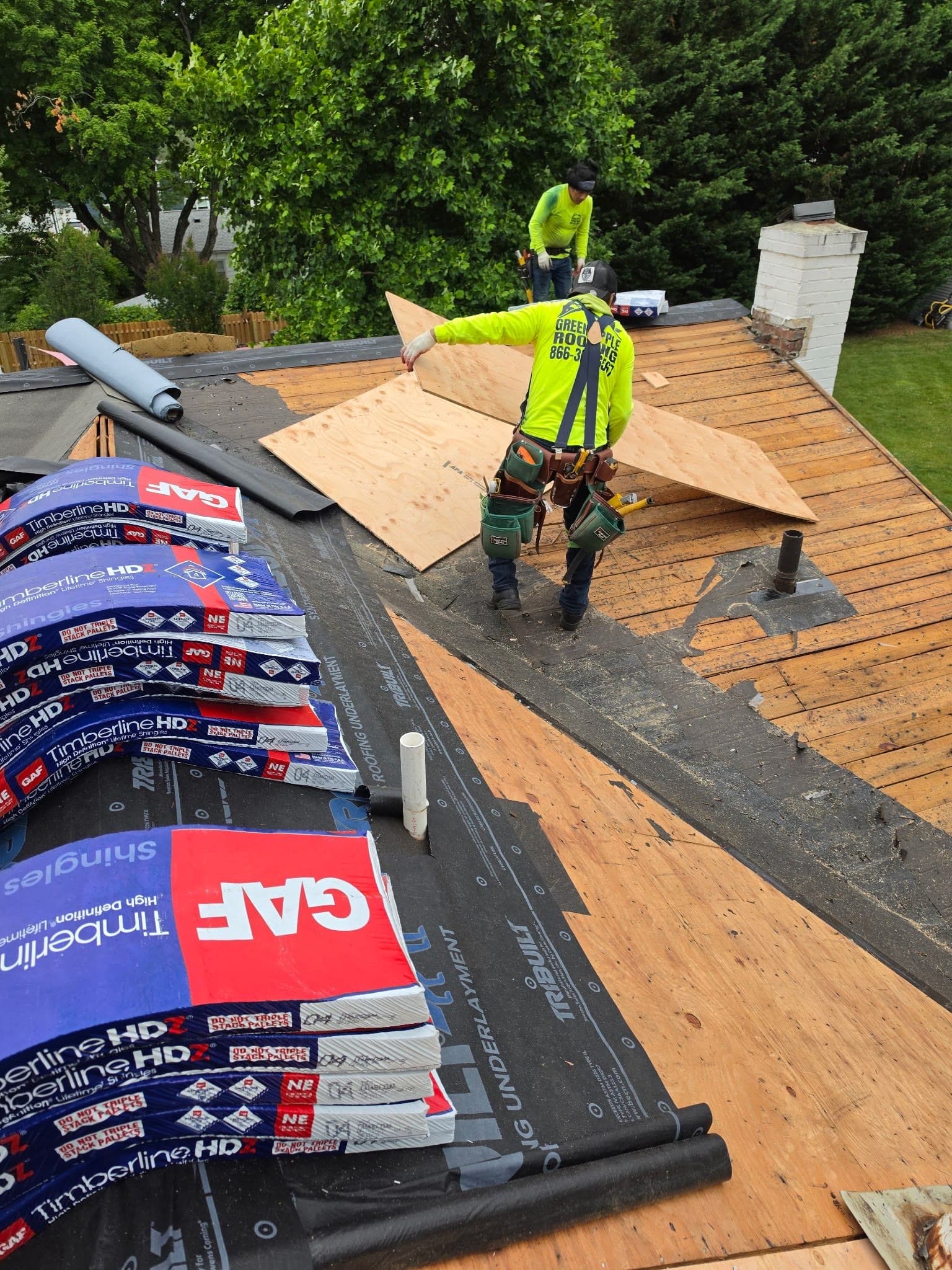 Cutting new plywood decking with GAF shingle bundles staged — Green Apple Roofing, New Jersey