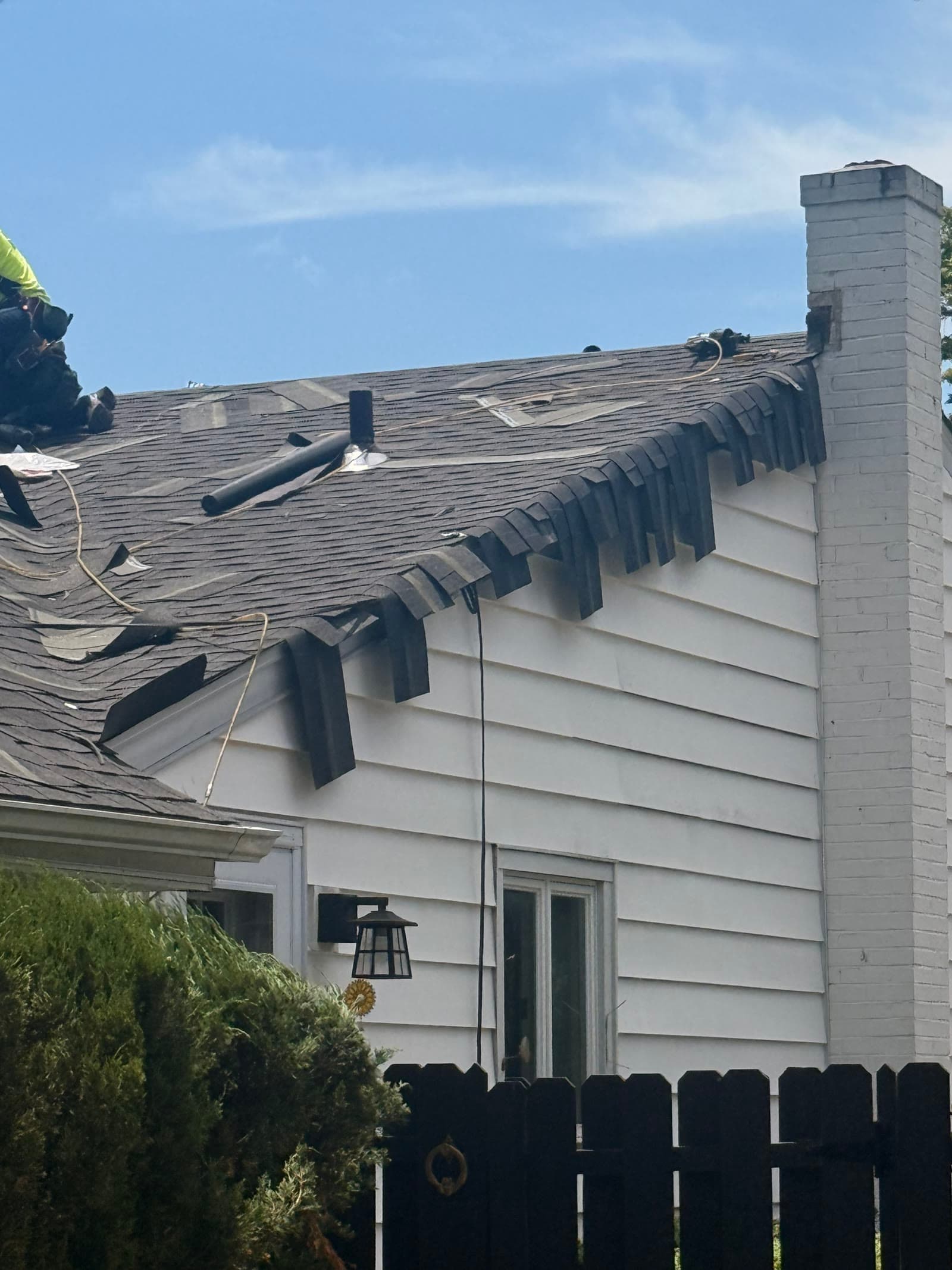 A storm-damaged roof with curled shingles by the chimney — Green Apple Roofing, New Jersey