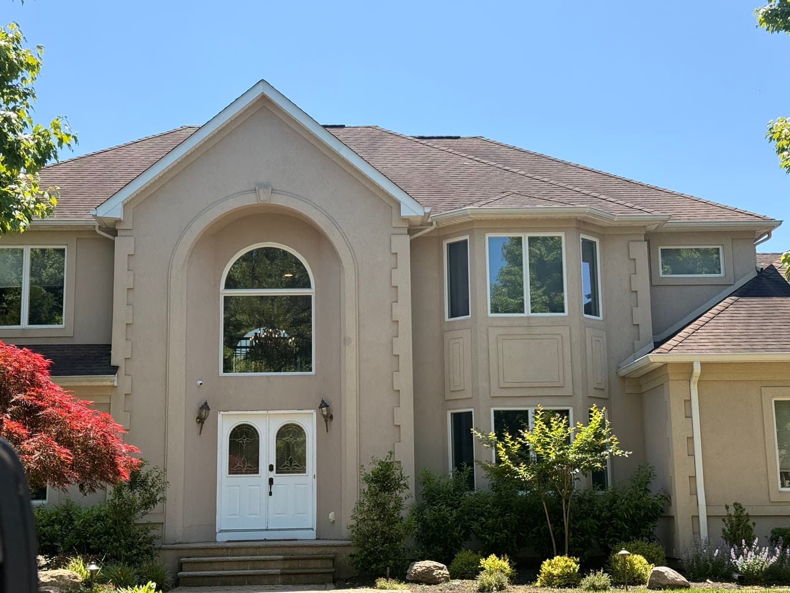 A New Jersey home with arched entry and windows completed by Green Apple Roofing