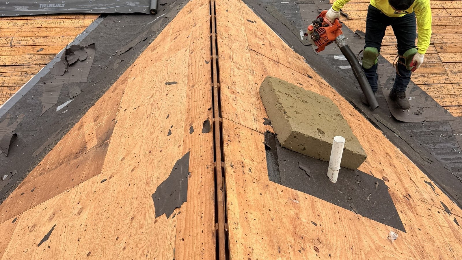 A Green Apple Roofing crew member installing a new roof on the deck of a New Jersey home — the workmanship a warranty depends on
