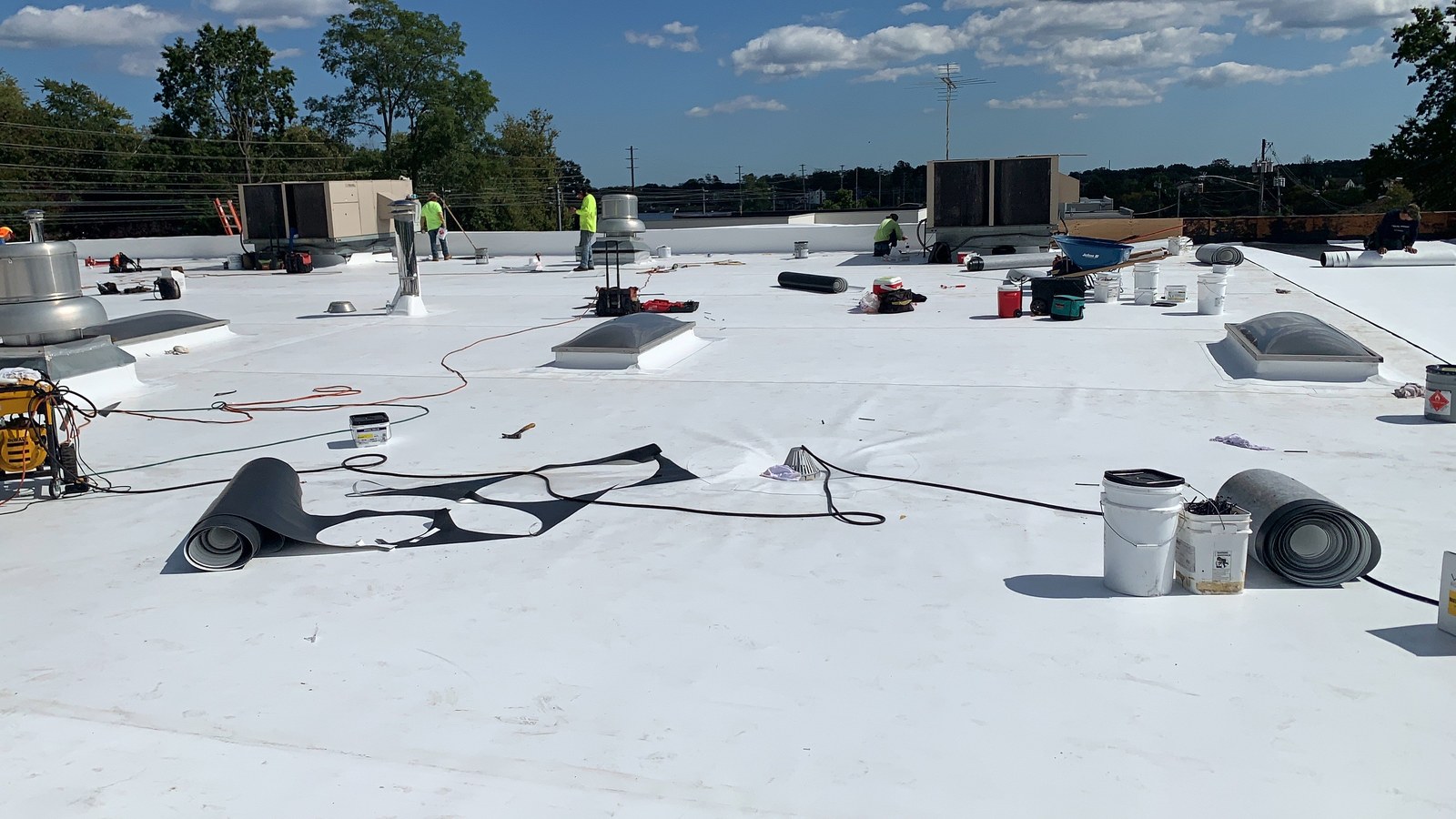 A large commercial TPO flat roof in New Jersey with rooftop HVAC units, drains, and vents that a maintenance program keeps in check