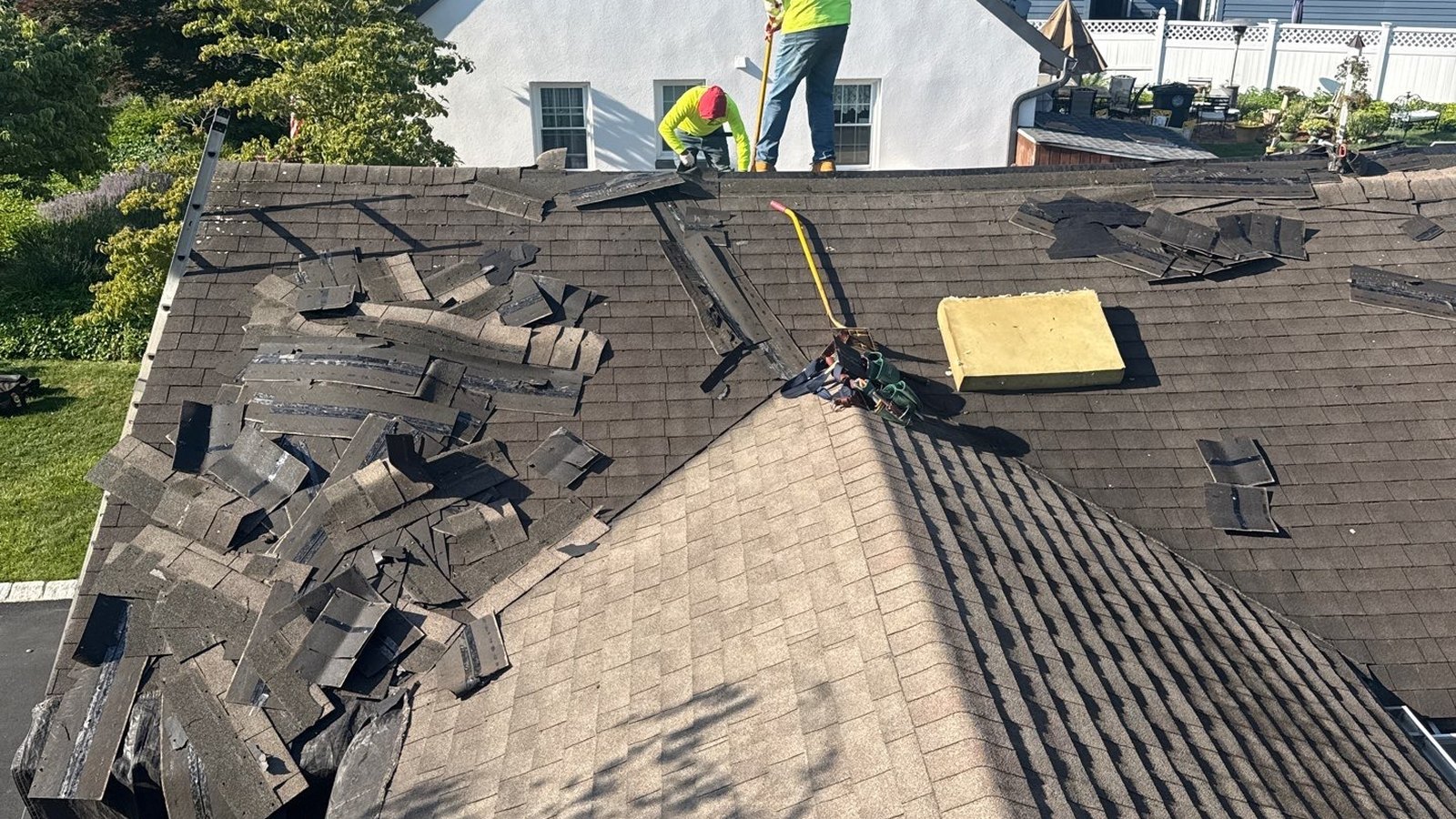 A Green Apple Roofing crew member on a New Jersey home's roof during a full shingle tear-off and replacement