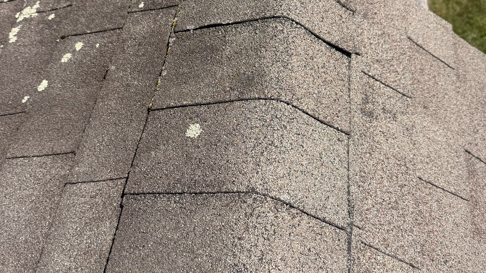 An aging asphalt shingle roof on a New Jersey home showing granule loss and curling shingles — a sign it needs replacing