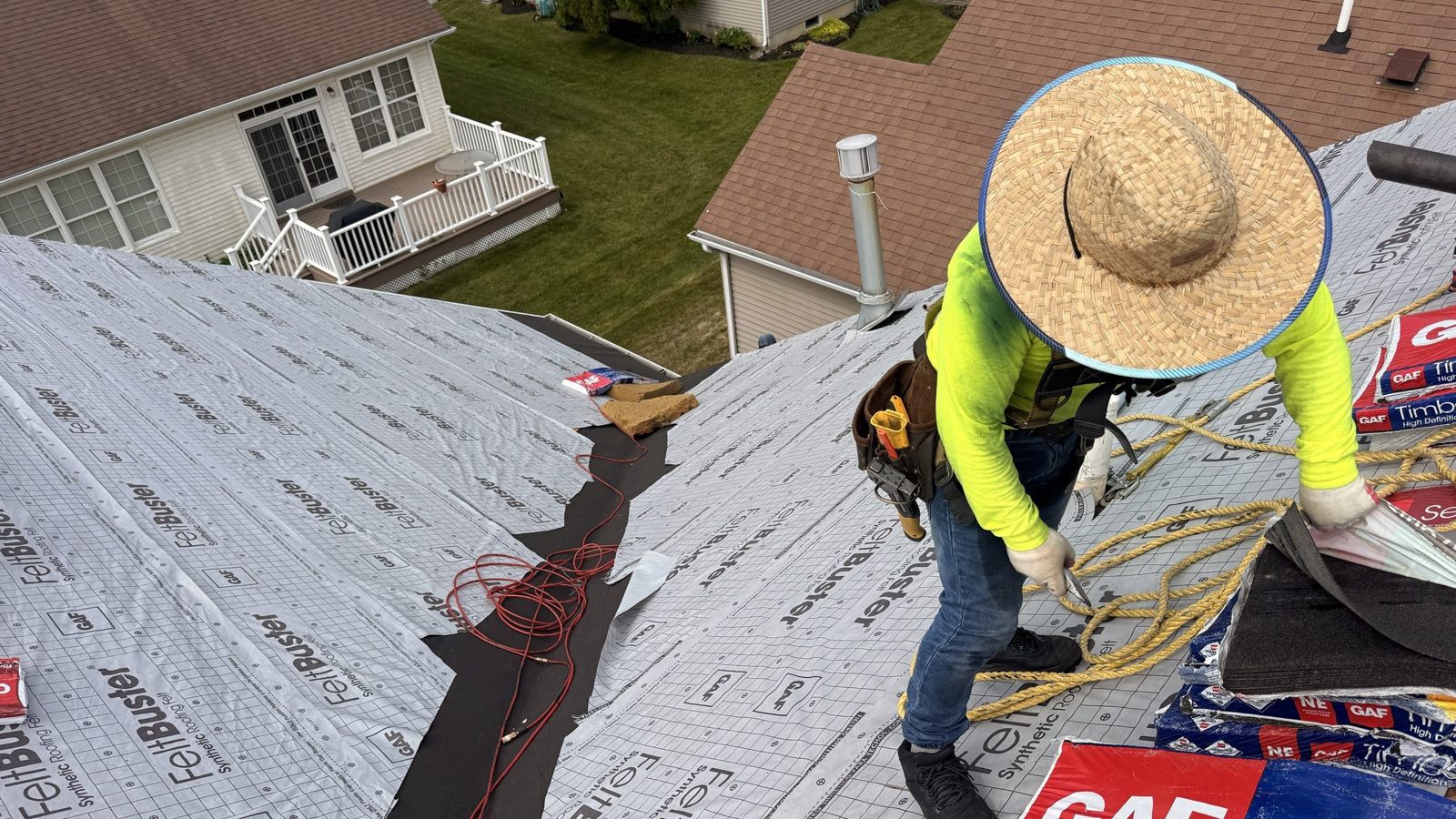 A New Jersey roof stripped to the deck and covered in synthetic underlayment, with self-adhering membrane run up the valley and shingle bundles staged along the ridge
